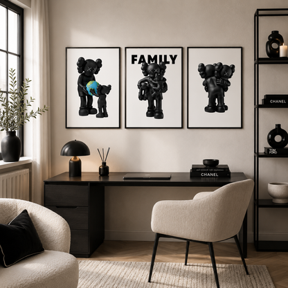 A styled interior room with three framed black-and-white wall art prints featuring cartoon bear figures, hung above a dark desk and chair. The scene includes a sofa, lamp, shelving, rug, and decor, but the likely product being sold is the wall art set rather than the furniture.