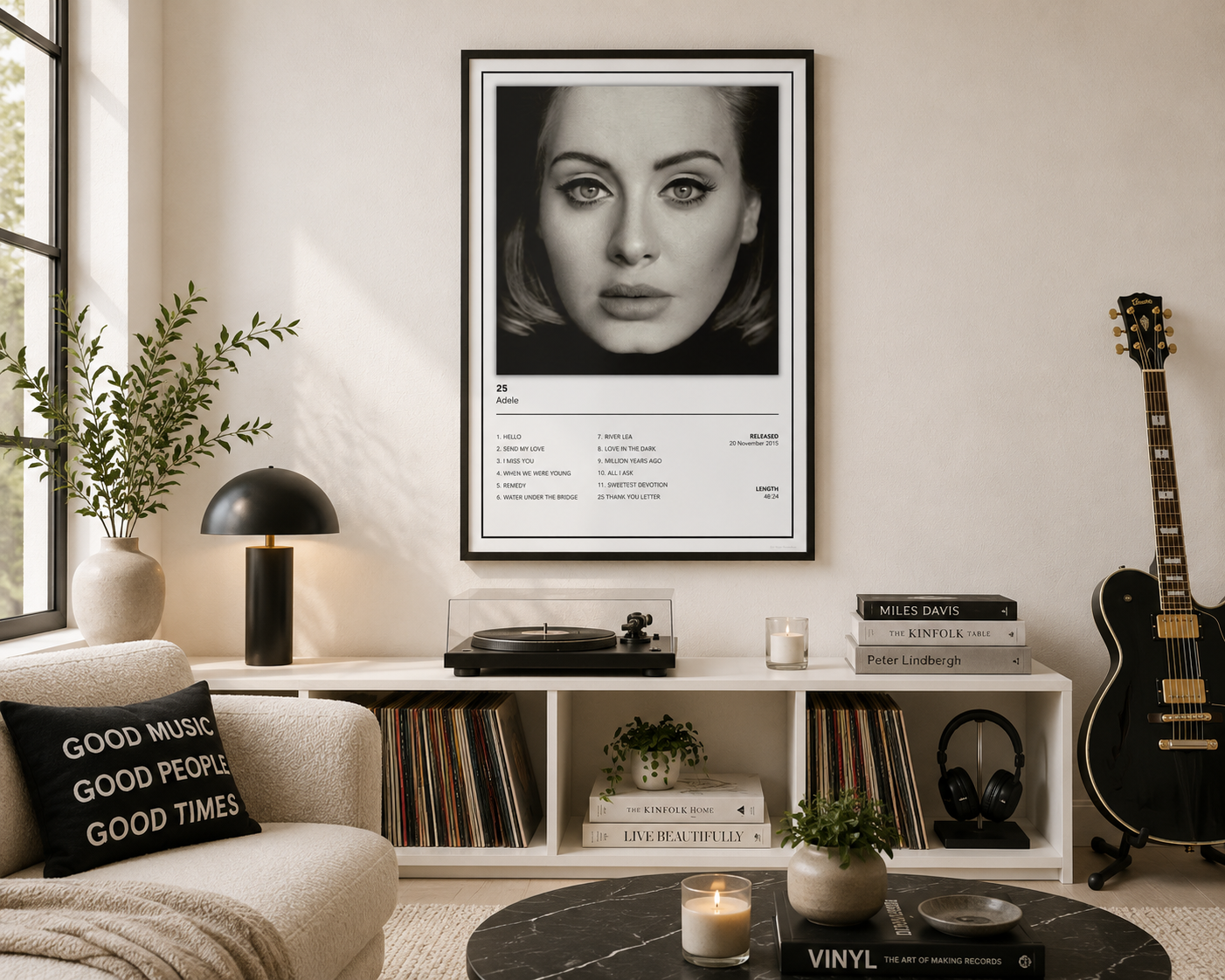A framed black and white portrait poster of Adele is displayed on a wall in a modern, stylishly decorated living room with a sofa, record player, and guitar.