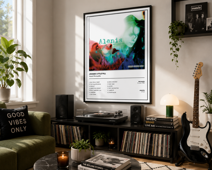 A framed music poster of Alanis Morissette's 'Jagged Little Pill' displayed on a wall in a modern, styled living room with a green couch, record store shelves, and a guitar.