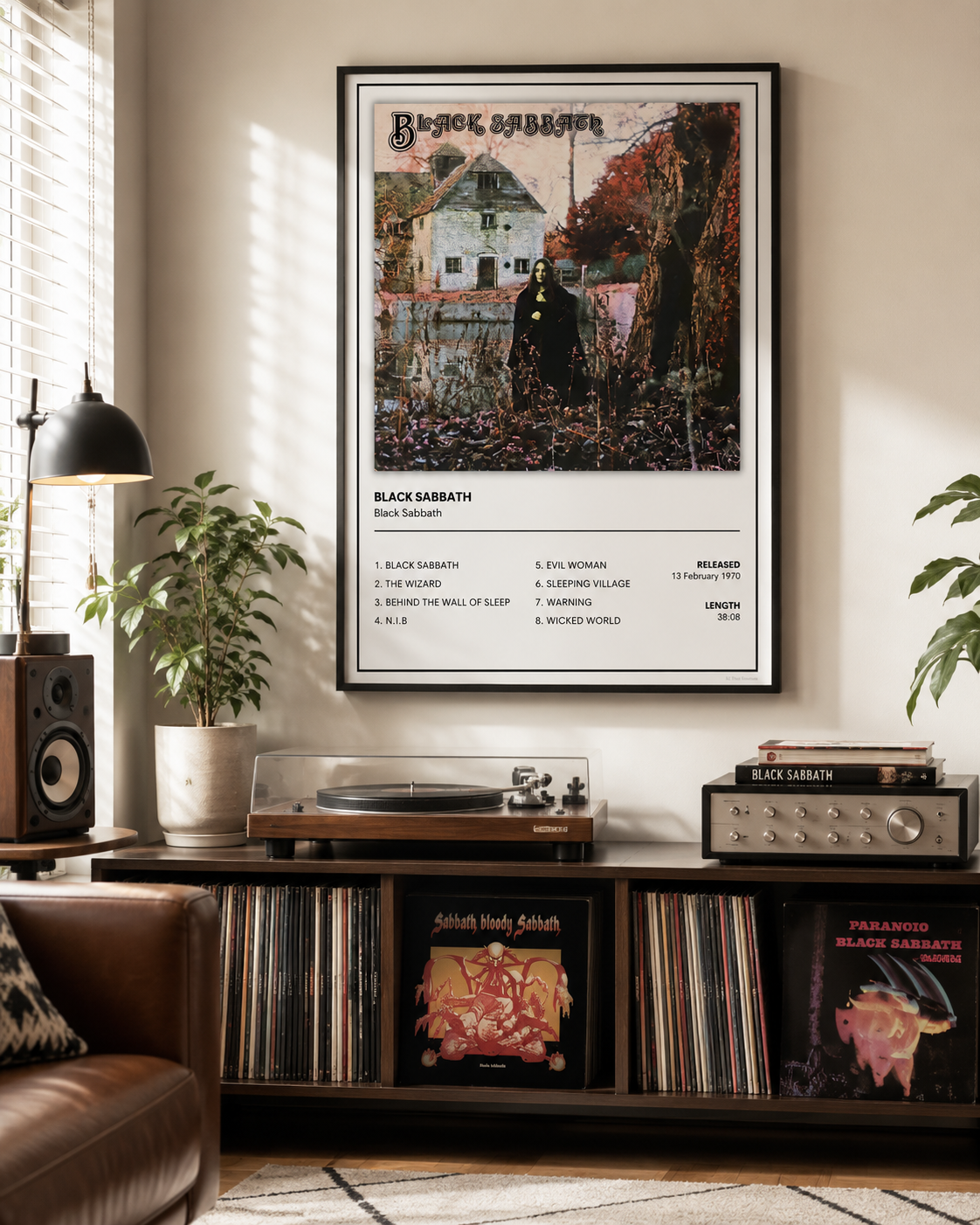 A framed Black Sabbath music poster hanging on a beige wall above a wooden record cabinet in a styled room with plants, speakers, and a record player.