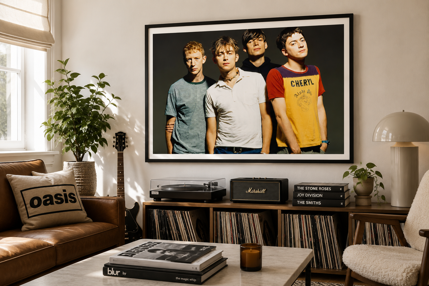 A large framed wall art print of the band Oasis is displayed in a cozy, sunlit living room above a record store counter. The print features the four band members in casual t-shirts against a dark background, enclosed in a sleek black frame.