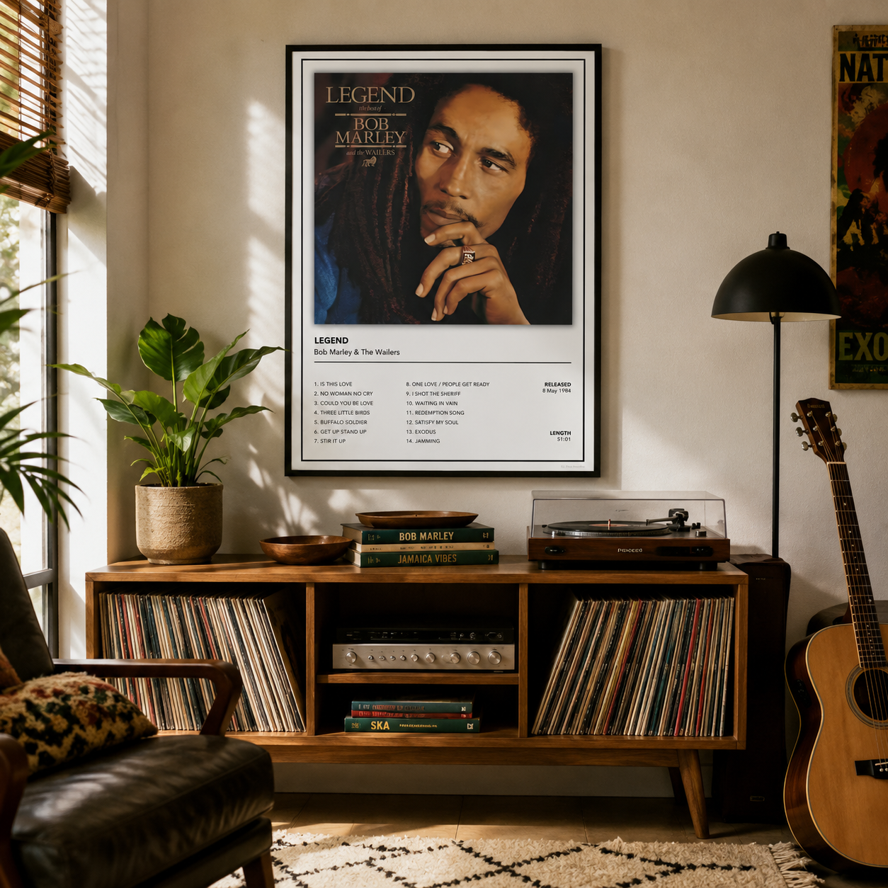 A framed Bob Marley 'Legend' poster hangs on a beige wall above a wooden record cabinet in a styled living room with a record player, guitar, plant, and leather chair.
