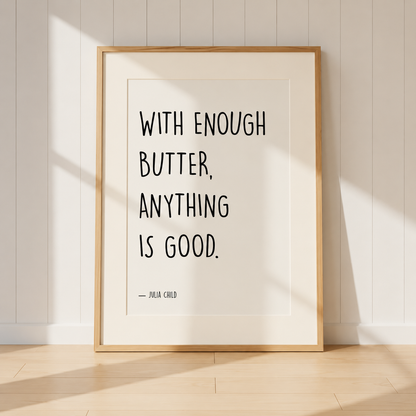 Julia Child quote print featuring "With Enough Butter, Anything Is Good" in a light oak frame with a warm ivory mount styled in a cosy farmhouse kitchen.
