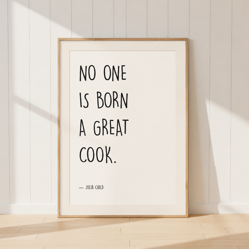 Neutral Julia Child kitchen quote print featuring the words "No One Is Born A Great Cook" in minimalist black typography, finished with a warm ivory mount and light oak frame, ideal for farmhouse and French country kitchens.