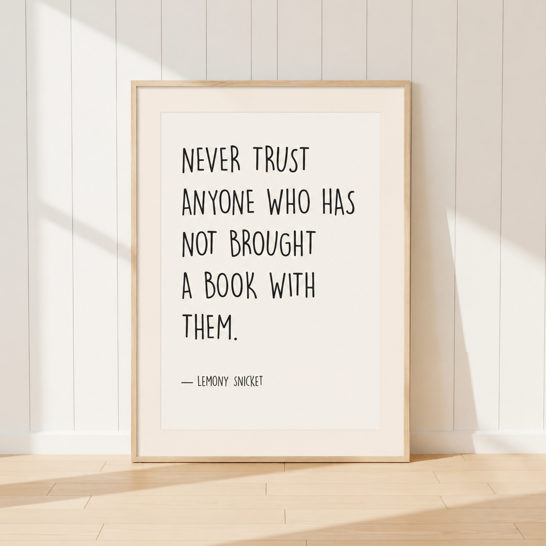 Minimalist Lemony Snicket quote print featuring the words "Never Trust Anyone Who Has Not Brought A Book With Them" in black typography, finished with a warm ivory mount and light oak frame, perfect for reading rooms and home libraries.