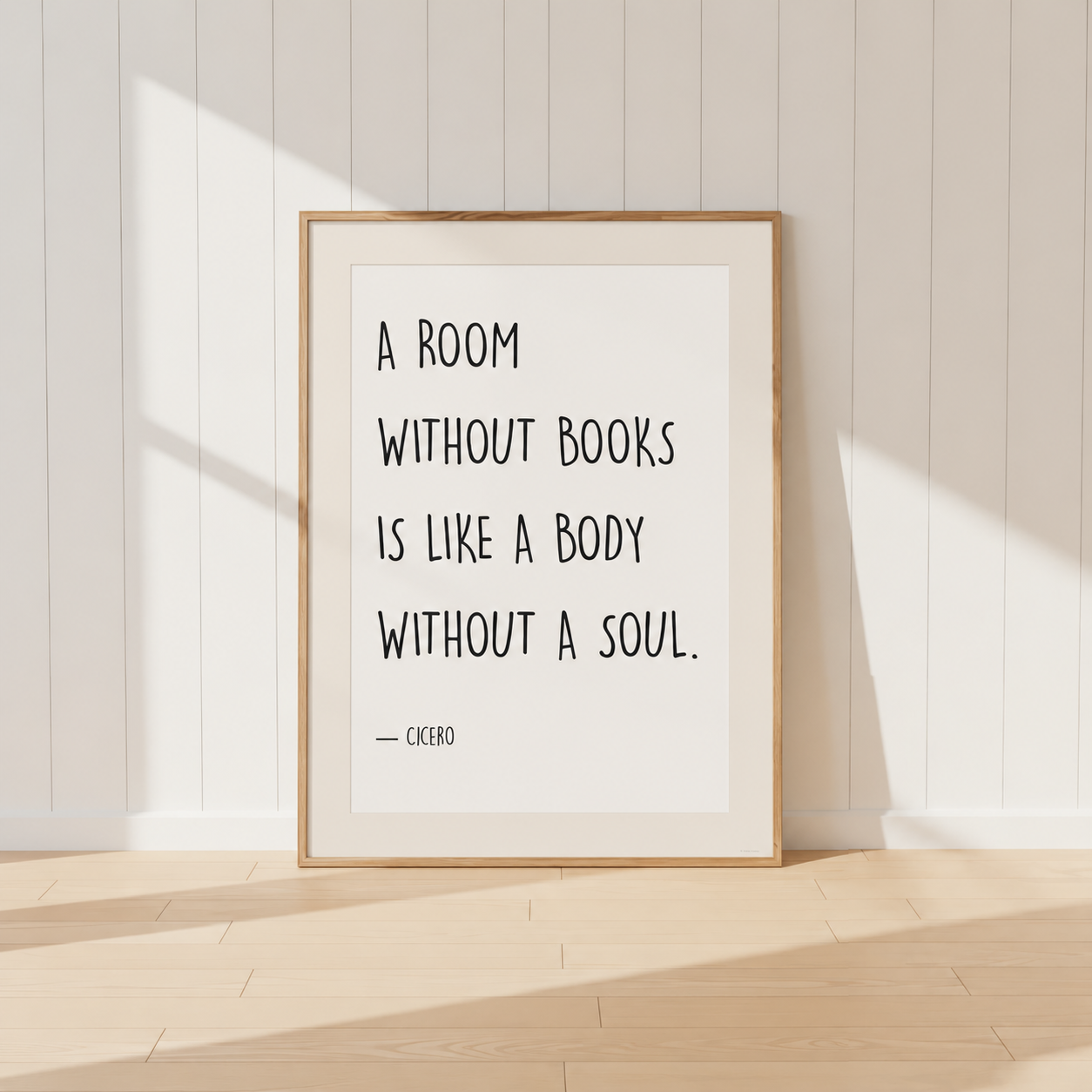 Minimalist Cicero quote print featuring the words "A Room Without Books Is Like A Body Without A Soul" in black typography, finished with a soft neutral mount and light oak frame, perfect for home libraries and reading rooms.