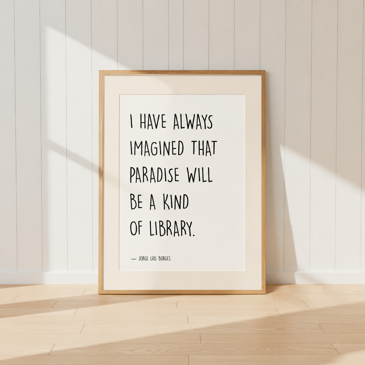 Minimalist Jorge Luis Borges quote print featuring the words "I Have Always Imagined That Paradise Will Be A Kind Of Library" in black typography, finished with a soft natural mount and light oak frame, perfect for home libraries and reading rooms.