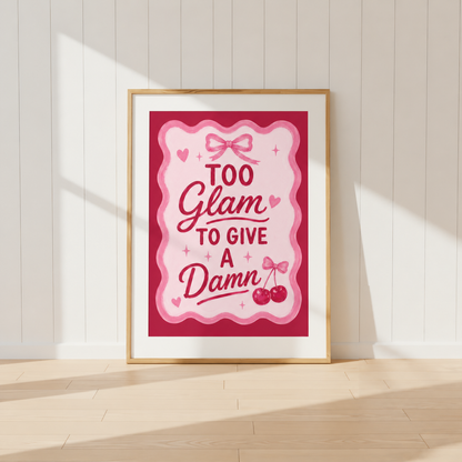 Too Glam To Give A Damn pink coquette wall art print featuring bow and cherry illustrations in a light oak frame.
