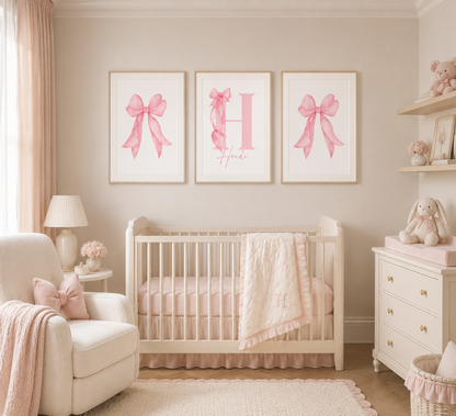 Nursery room with a crib, chair, and wall art featuring pink bows and letters.