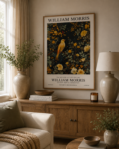 William Morris inspired yellow bird print displayed above a wooden sideboard in a neutral living room with botanical decor and warm natural lighting.