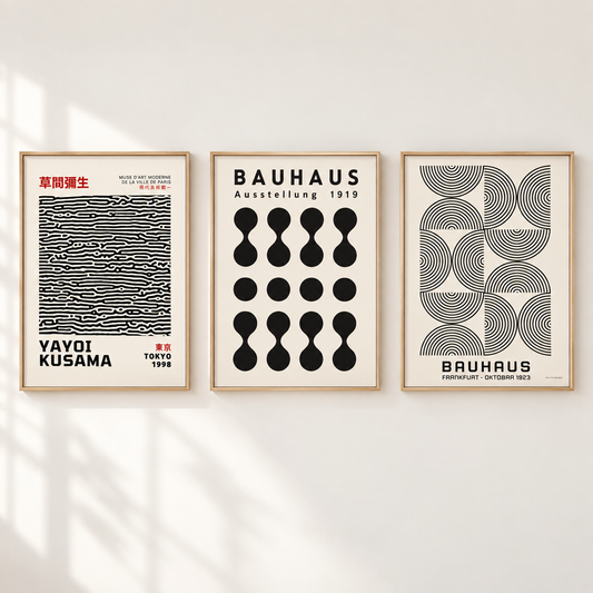 Three framed Bauhaus-style art prints hang on a light wall with soft shadow overlays. The left print features black-and-white wavy lines with red text and the name VAYOI KUSAMA; the center print shows black geometric droplet shapes with the word BAUHAUS; the right print has black concentric curved lines with BAUHAUS and BRUHAUS text.