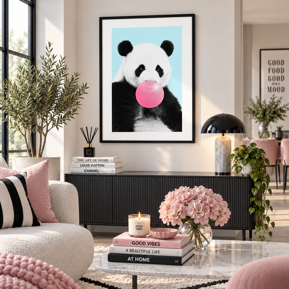 A framed art print featuring a panda blowing a pink bubblegum bubble, hung on a beige wall in a modern, stylishly decorated living room.