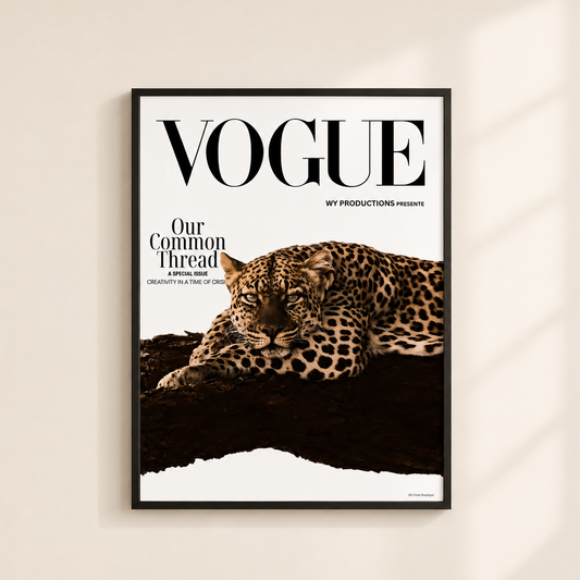 A framed Vogue magazine cover print hangs on a warm off-white wall. The poster features a leopard lying on a dark surface with the large black VOGUE title at the top and smaller text reading 'Our Common Thread' and 'WY PRODUCTIONS presents.