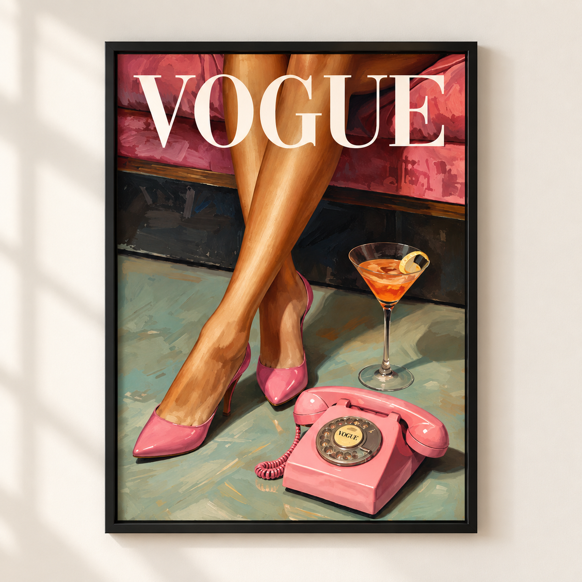 A framed art print featuring a stylized illustration of a woman's legs in pink high heels beside a pink rotary phone and a martini glass, with the word 'VOGUE' across the top, displayed on a light wall.
