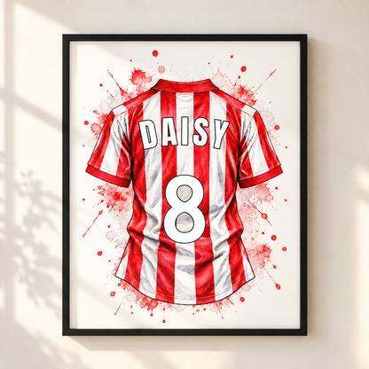 Framed wall art featuring a stylized red and white striped soccer jersey with the name DAISY and number 8, shown hanging on a light beige wall with soft window shadows.