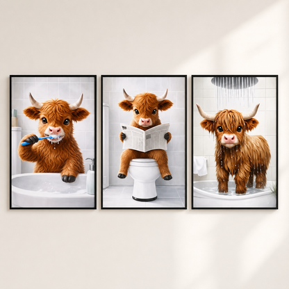 Three framed wall art prints showing a fluffy brown Highland cow in bathroom scenes, displayed side by side on a light beige wall. The left print shows the cow brushing its teeth in a sink, the center shows it reading a newspaper on a toilet, and the right shows it standing in a shower under running water.