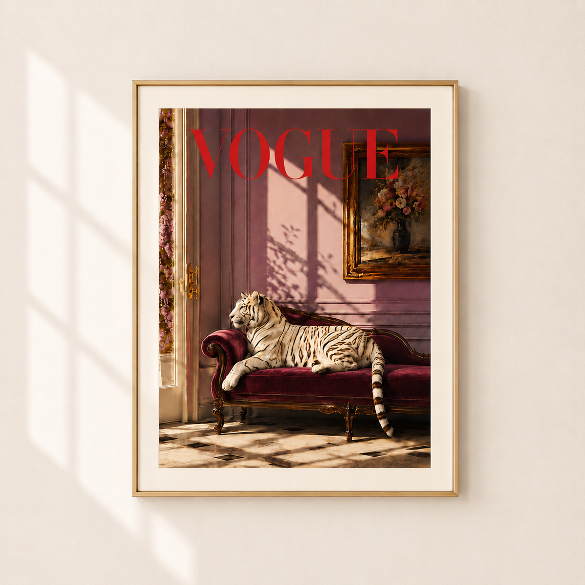 A framed art print featuring a white tiger lounging on a burgundy chaise lounge, styled like a vintage Vogue magazine cover with red 'VOGUE' lettering, hanging on a light beige wall with soft window shadow patterns.