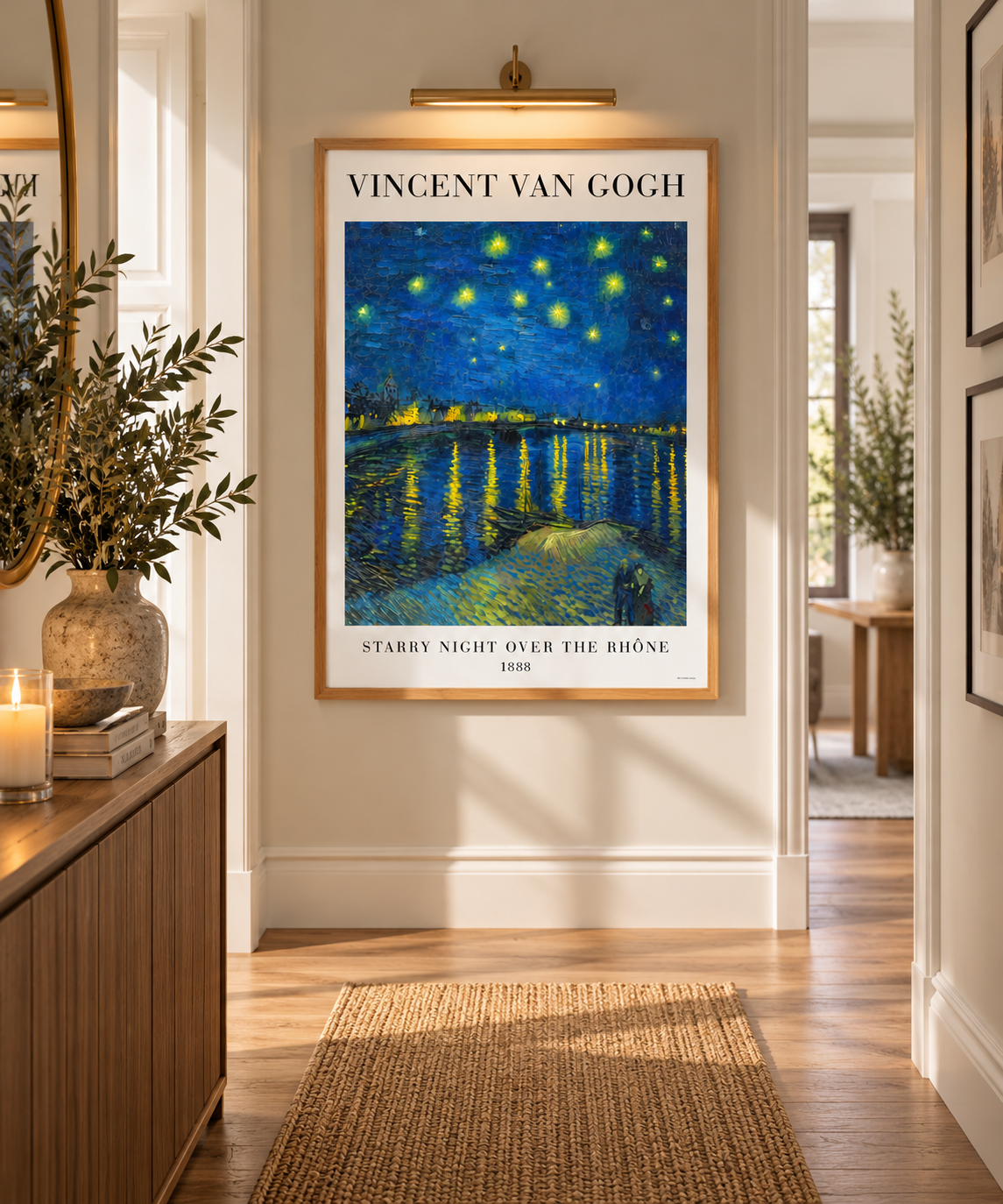 A framed Vincent van Gogh poster of 'Starry Night Over the Rhone' hangs on a beige wall in a styled hallway with a wooden console table, candles, and a woven rug.