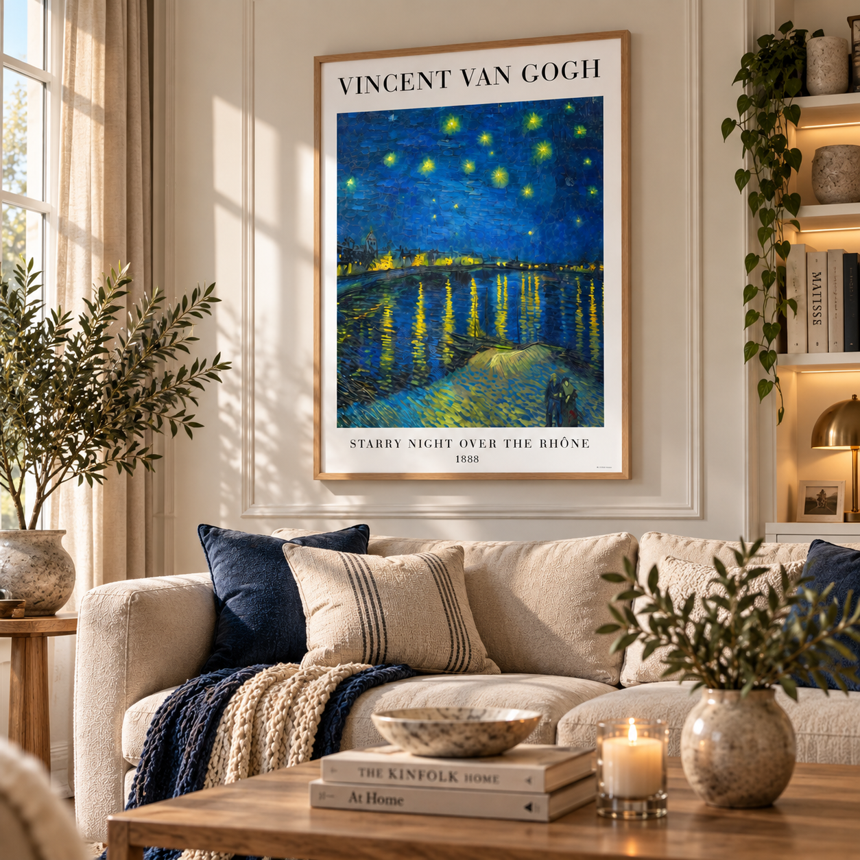 A framed Vincent van Gogh poster of 'Starry Night Over the Rhone' hangs on a cream wall above a beige sofa in a styled living room with plants, pillows, and a coffee table.