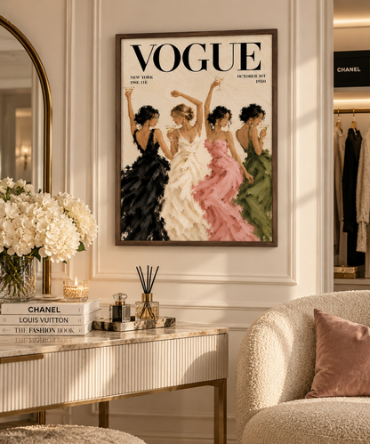 A framed Vogue magazine cover print hangs on a cream wall in a styled interior. The artwork shows four women in elegant dresses in black, white, pink, and green.