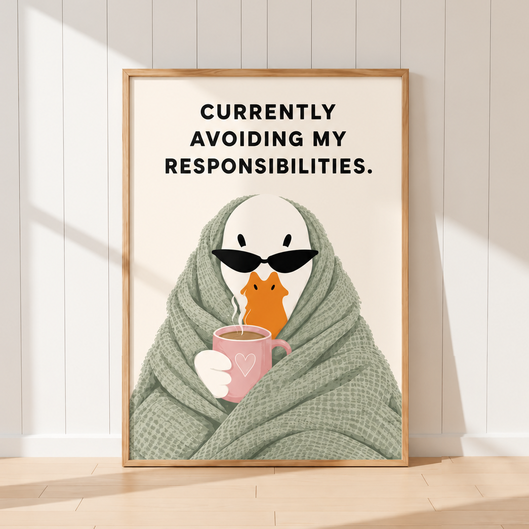 A framed art print leaning against a white paneled wall on a light wood floor. The print features a cartoon penguin wrapped in a green blanket and wearing black sunglasses, holding a pink mug.