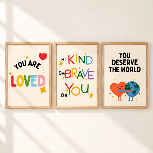 Three framed motivational wall art prints hang side by side on a light wall with soft diagonal shadows. The left print says 'YOU ARE LOVED' with a red heart balloon and multicolor lettering.