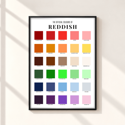 A framed poster titled 'THE OFFICIAL COLOURS OF REDDISH' hangs on a light beige wall. The poster features a grid of 36 color swatches ranging from reds and oranges to greens, blues, purples, and pinks, with labels underneath each square.