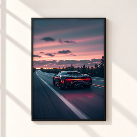 A framed vertical wall art print showing a dark sports car on a highway at sunset, mounted on a light beige wall with soft window shadow patterns.