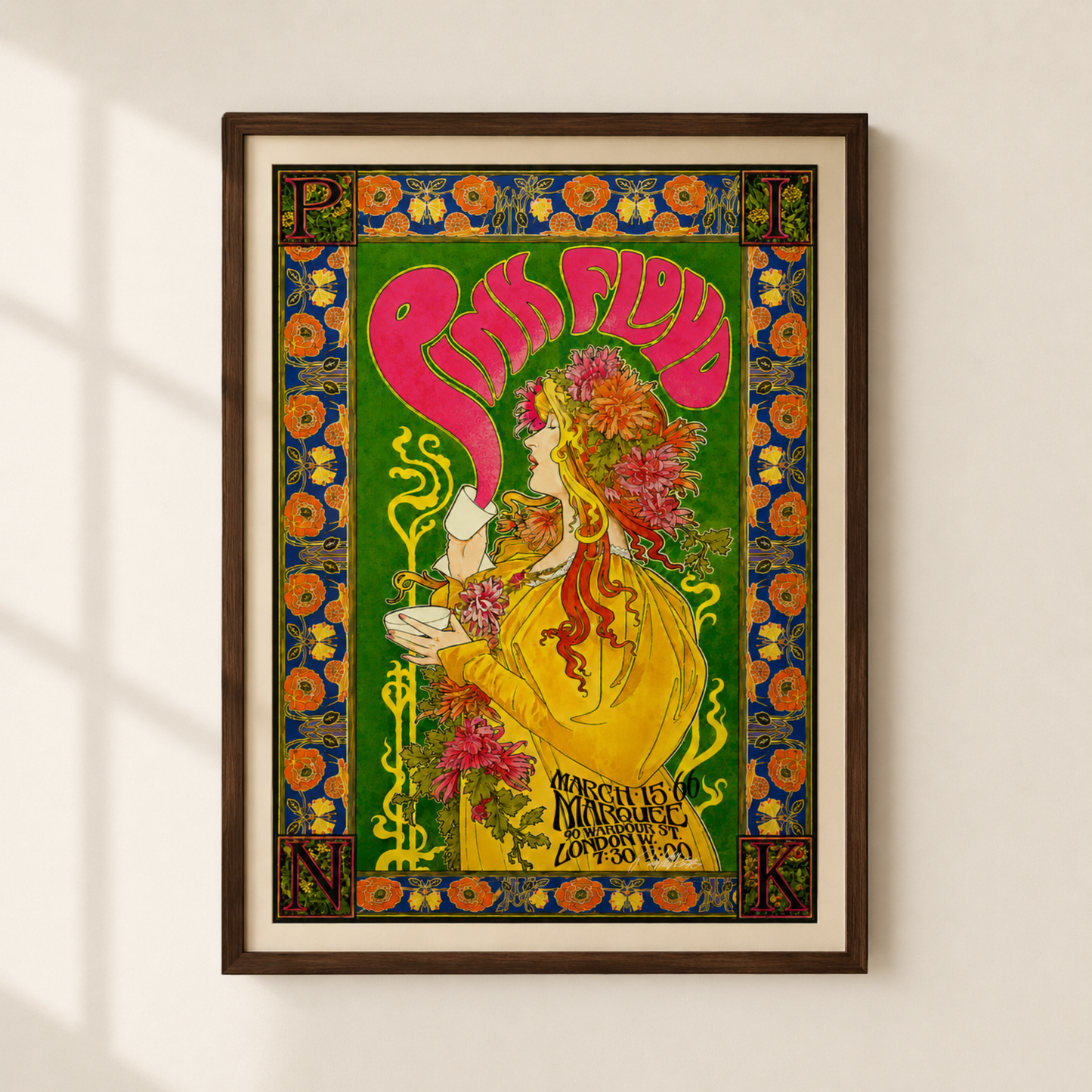 A framed vintage-style poster print hanging on a light beige wall. Pink Floyd, Marquee 1960. The artwork features a woman in a yellow dress with large pink lettering above her head, surrounded by ornate floral and geometric borders in green, blue, orange, and yellow.