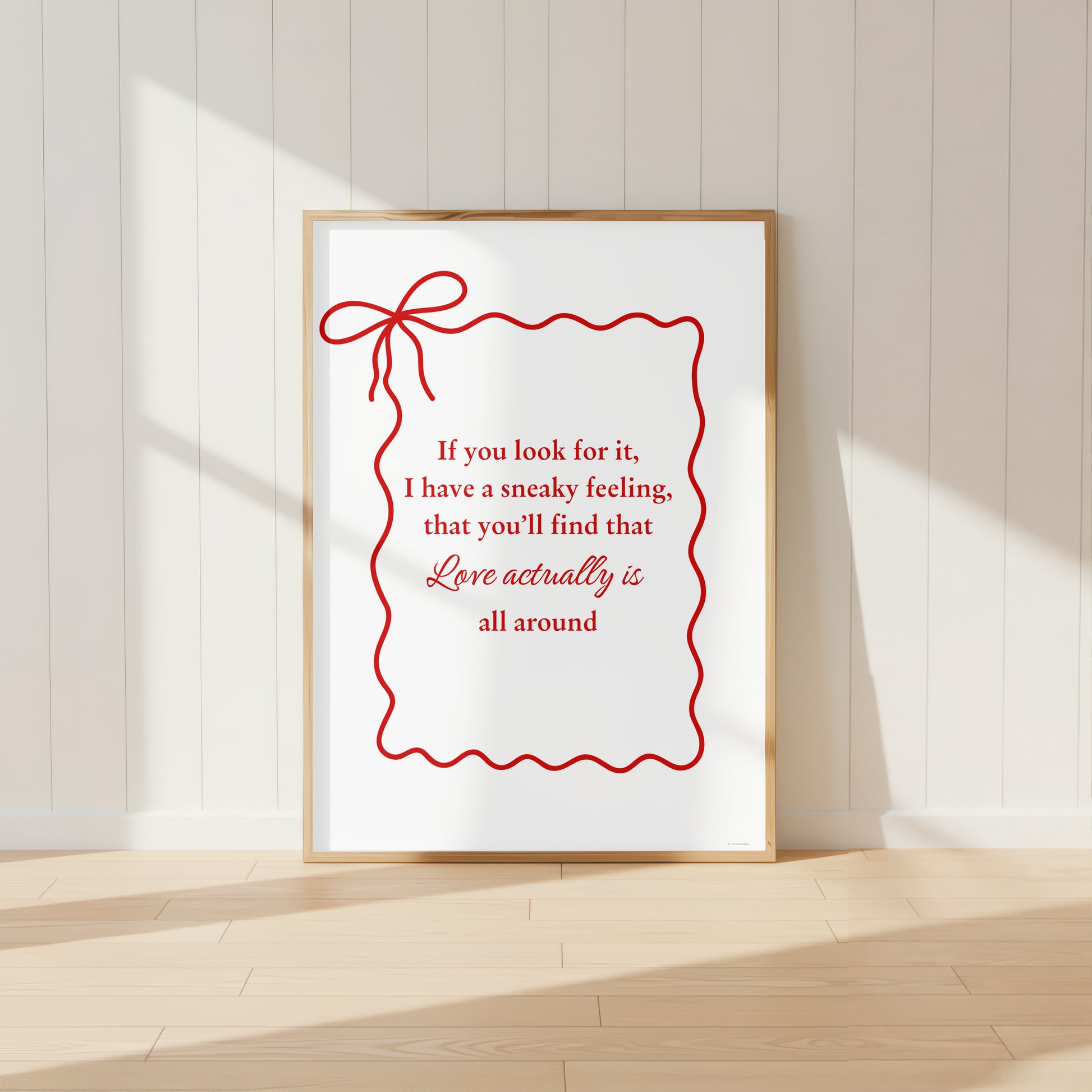 Love Actually quote wall art print with elegant red bow design in light oak frame.