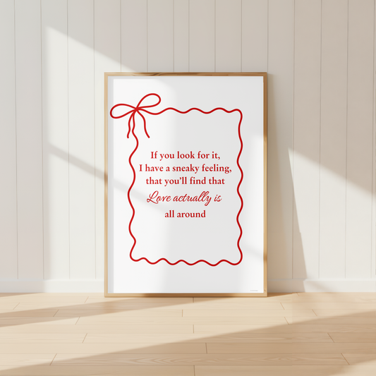 Love Actually quote wall art print with elegant red bow design in light oak frame.