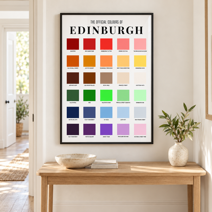 A framed poster titled 'THE OFFICIAL COLOURS OF EDINBURGH' hangs on a white wall above a wooden console table. The poster features a grid of color swatches with labels.