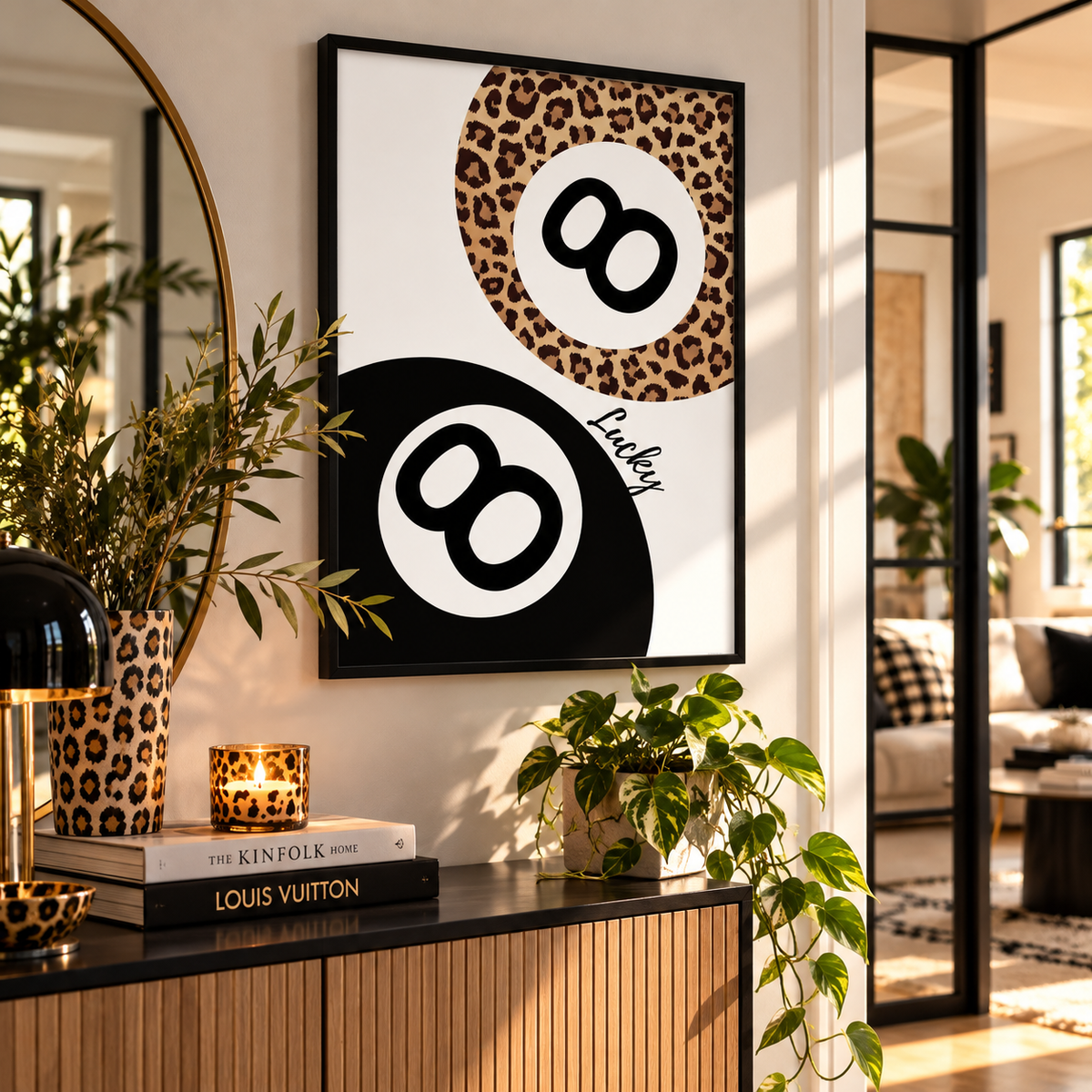 A framed wall art print featuring two stylized billiard 8-ball designs in leopard print and black-and-white, displayed in a modern living room setting above a console table with books and plants.