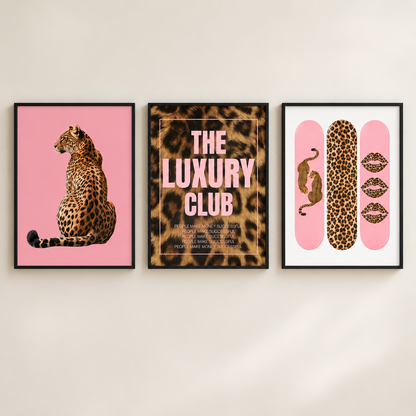Three framed fashion art prints hanging on a light beige wall. The left print shows a leopard on a pink background, the center print features a leopard print with the text 'THE LUXURY CLUB', and the right print displays leopard print on pink shapes with lips and a snake motif.