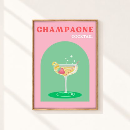 A framed art print featuring a retro-style illustration of a champagne cocktail on a pink background with the text 'CHAMPAGNE COCKTAIL' in coral and white lettering. The print is housed in a light wood frame and displayed on a warm off-white wall with soft diagonal shadows.