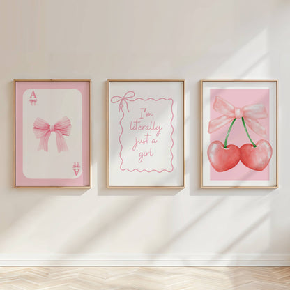 Pink coquette wall art prints featuring bows, cherries and feminine typography styled in a luxury vanity room.