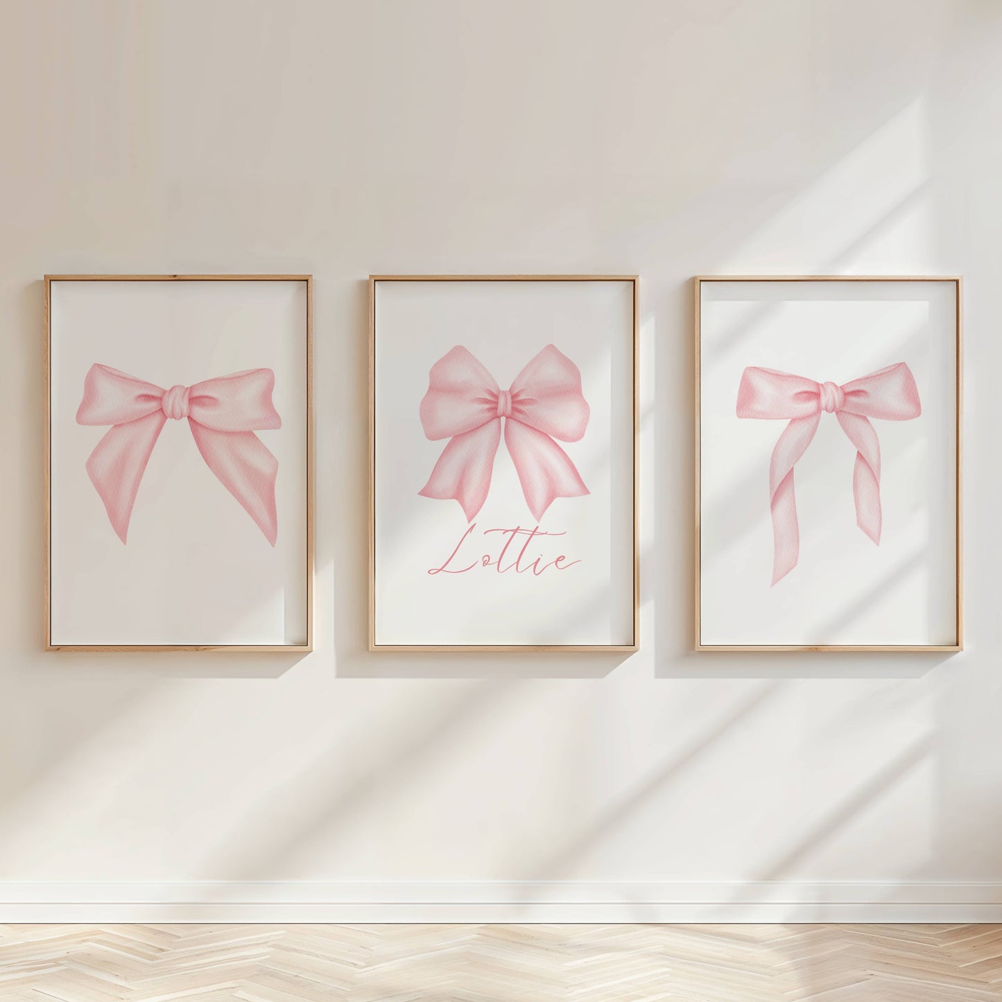 Personalised pink bow wall art prints styled above a blush pink girls bedroom bed with soft feminine decor.