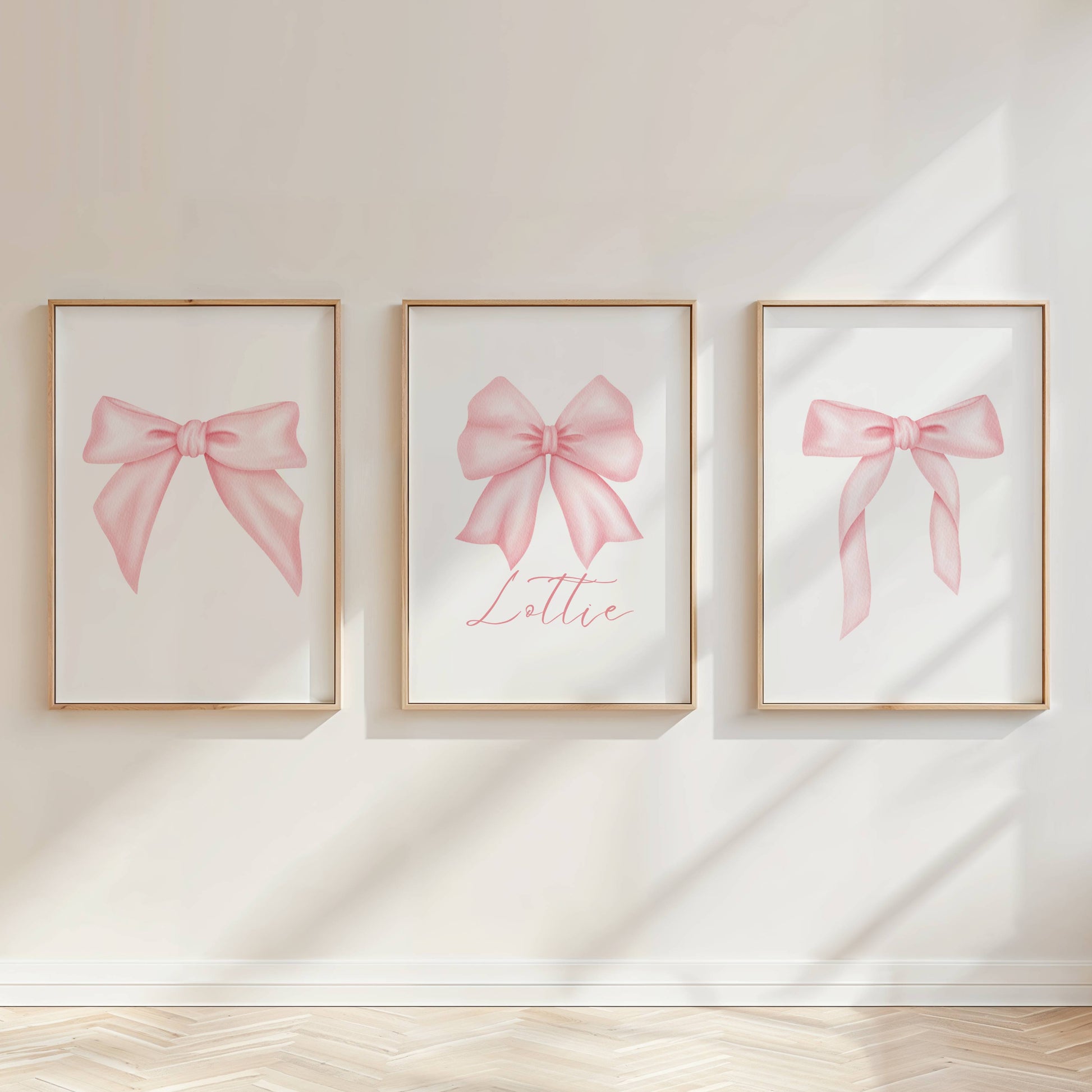 Personalised pink bow wall art prints styled above a blush pink girls bedroom bed with soft feminine decor.