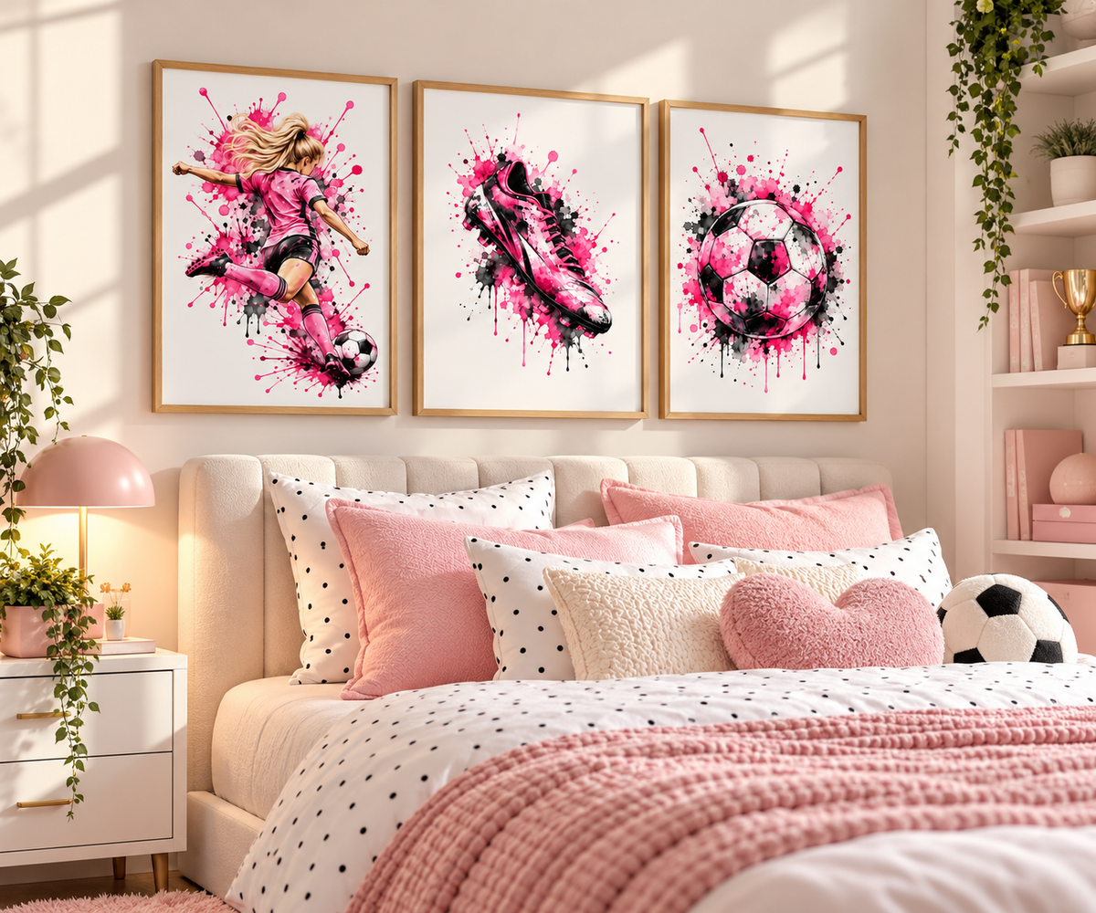 A styled bedroom scene with three framed wall art prints above a bed. The prints feature pink and black watercolor-style illustrations of a soccer player, a soccer cleat, and a soccer ball on white backgrounds with gold frames.