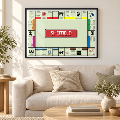Sheffield Monopoly-style print displayed above a beige sofa in a bright neutral lounge, with a black landscape frame and colourful board design.