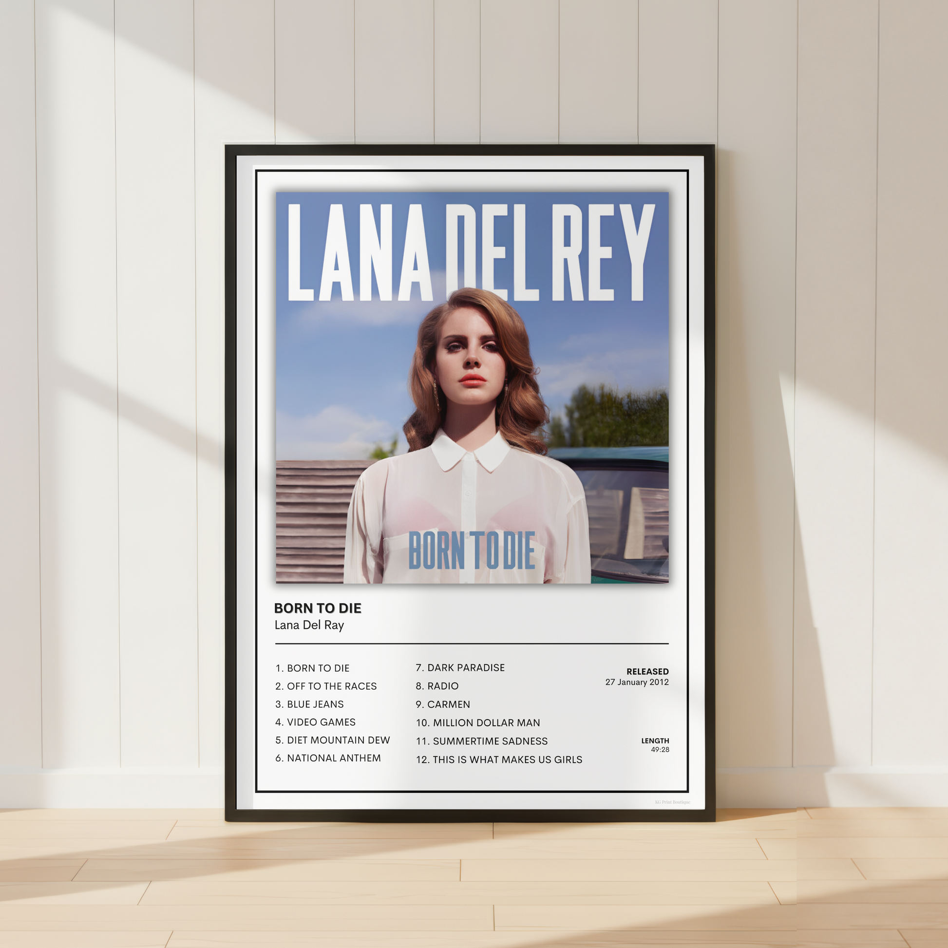 Framed Lana Del Rey Born To Die album cover print displayed in a bright modern living room with contemporary music-inspired décor.