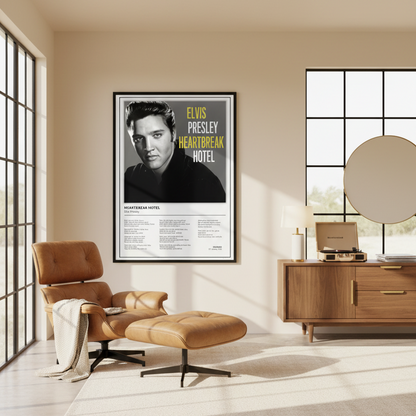 A framed vertical poster of Elvis Presley's 'Heartbreak Hotel' leaning against a white paneled wall on a light wood floor, with soft window shadows cast across the scene.
