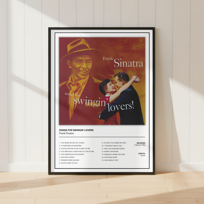A framed Frank Sinatra 'Swingin' Lovers' music poster is displayed leaning against a white paneled wall on a light wood floor, with soft sunlight casting shadows.