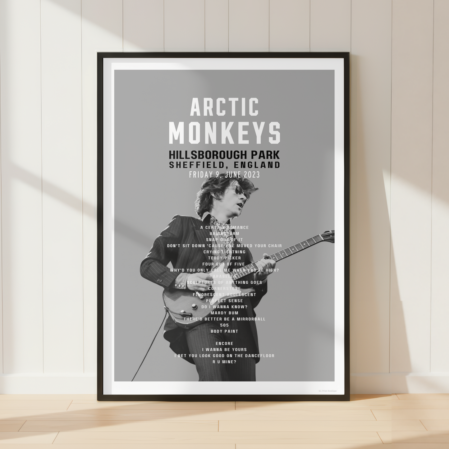 Premium Arctic Monkeys concert poster print showcasing the Hillsborough Park 2023 setlist in a bright contemporary living room with vinyl records and modern interiors.