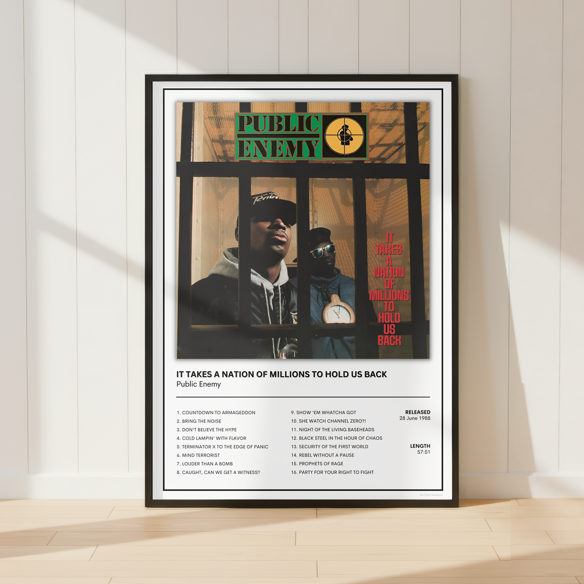 A framed music poster of Public Enemy's album 'Public Enemy' leaning against a white paneled wall on a light wood floor, with soft window shadows cast across the scene.