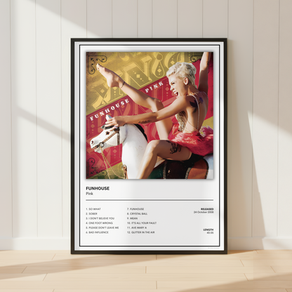 A framed music poster for Pink's album 'Funhouse' leaning against a white paneled wall on a light wood floor. The poster features a colorful album-cover photo of Pink on a carousel horse above a printed tracklist and release details.