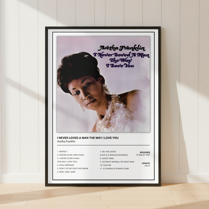 A framed music poster of Anita Franklin leaning against a white paneled wall on a light wood floor, with soft sunlight casting shadows.