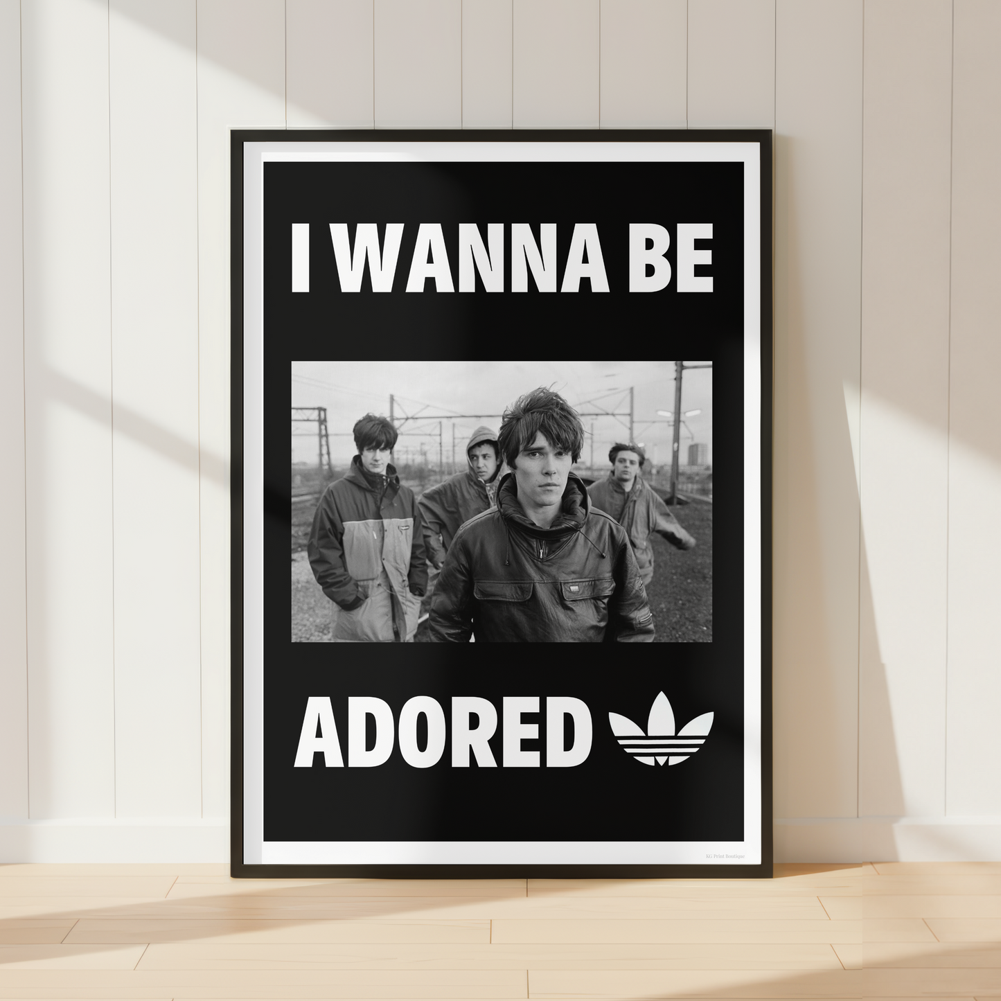 The Stone Roses "I Wanna Be Adored" lyric print displayed in a modern industrial home office with monochrome décor and minimalist styling.