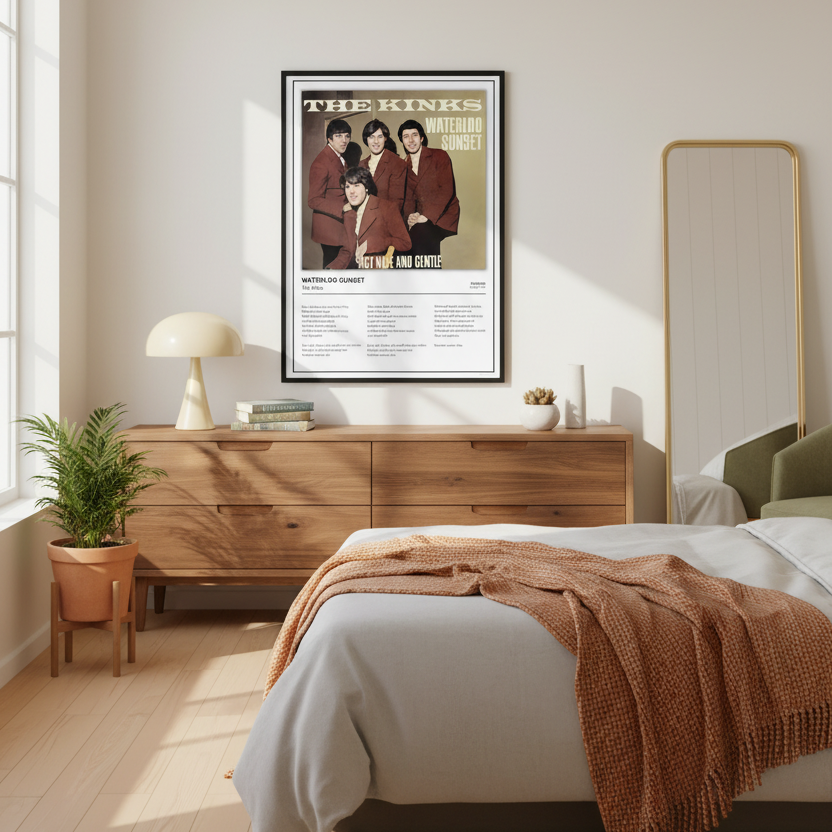 A framed music poster of The Kinks' 'Waterloo Sunset' leaning against a white paneled wall on a light wood floor, with soft window shadows cast across the scene.