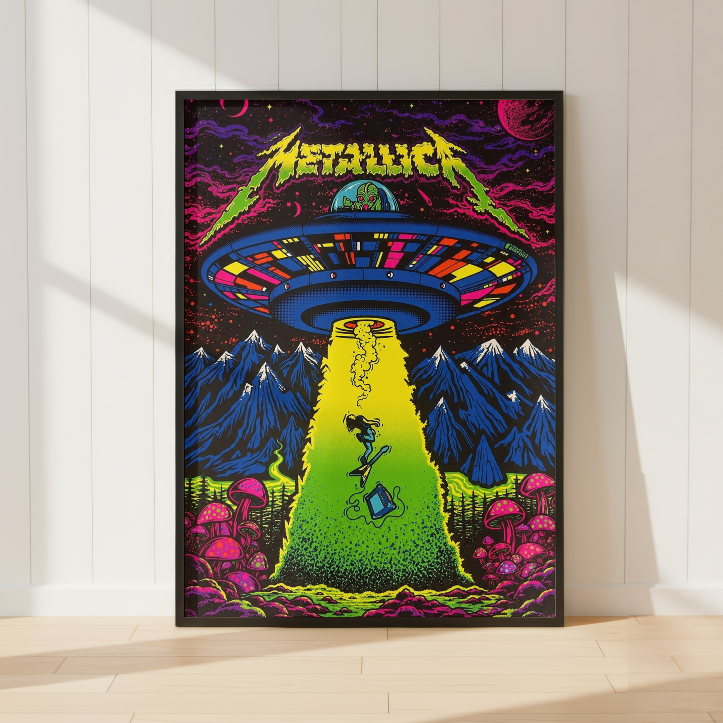 Metallica 'The Metal Era' poster leaning against a white paneled wall on a light wood floor. The poster features a vibrant, psychedelic illustration of a UFO releasing a beam of light over a green field with a figure, pink mushrooms, and blue mountains.